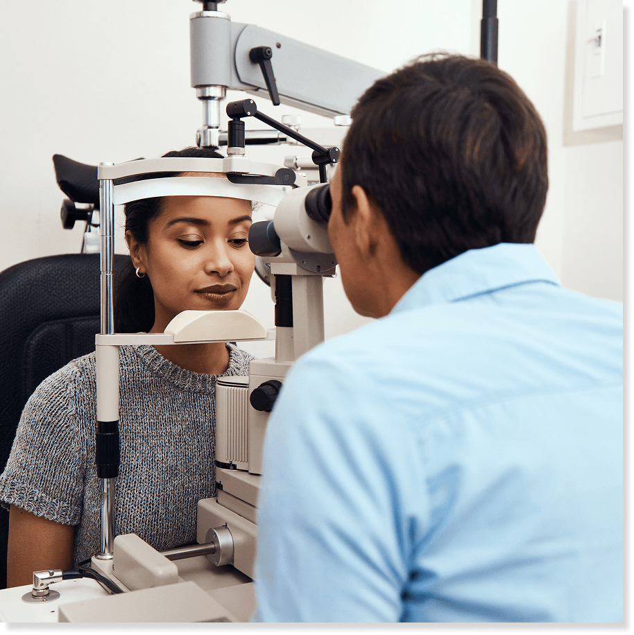 eye doctor performing an eye exam on a female patient in an eye doctor’s office